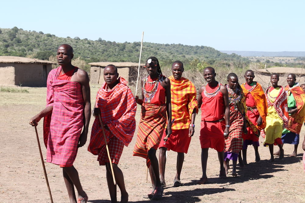 Maasai community members in red shuka walking together in Kenya